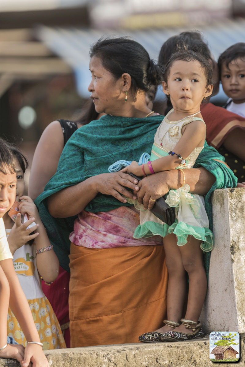 A mother and daughter watching Hyang Tannaba (boat race) at Moirang Leima Thangapat, Manipur